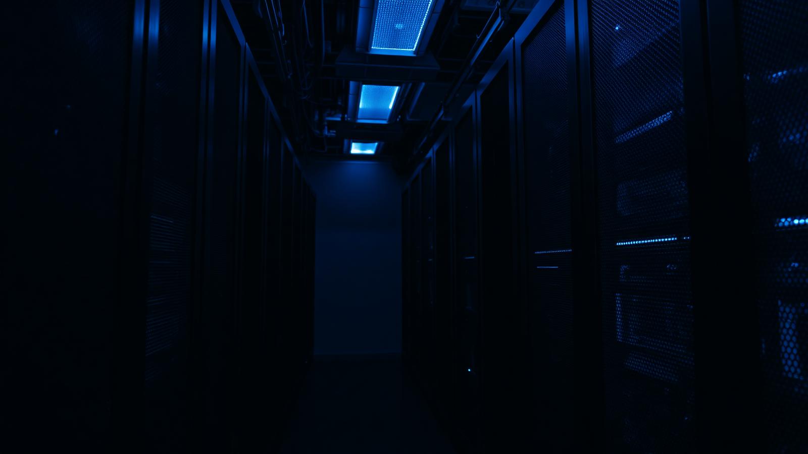 Corridoio di un data center illuminato di blu, infrastruttura delle reti blockchain